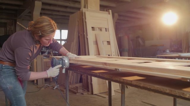 Woman sanding in a carpentry workshop