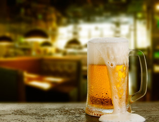 Mug with beer on the background of bar.