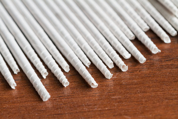 White newspaper tubules for newspaper weaving. Closeup, selective focus.