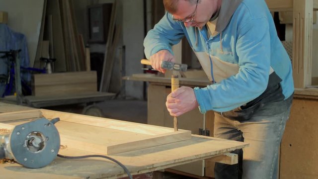 Carpenter carving a wooden frame