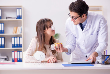 Male doctor talking to patient with nose operation surgery