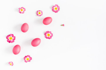 Easter pink eggs and primrose flowers on white background. Easter concept. Flat lay, top view, copy space