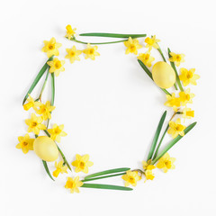 Easter eggs and yellow flowers on white background. Easter concept. Flat lay, top view, copy space, square