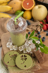 Matcha Green tea Smoothies and Matcha powder on a printed form and Chocolate on a wooden plate