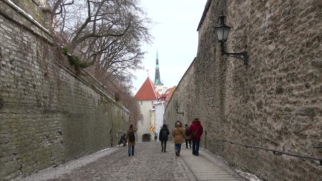 Tourists walk through the street Pikk jalg (Long leg). Toompea, Estonia