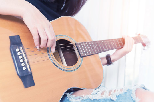 Playing the guitar. Guitar lessons. Acoustic guitar. Relax while playing the guitar in room.