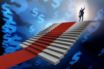 Young businessman climbing stairs and red carpet