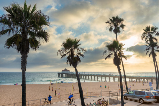 Palm trees and Pier at sunset in Manhattan Beach. Fashion travel and tropical beach concept. 