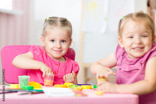 Two Cute Preschooler Girls Having Fun Together With Colorful