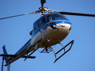 Blue helicopter flying on the blue sky