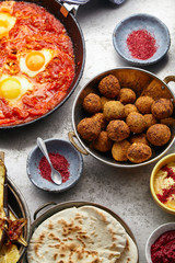 Close up shot of traditional jewish and middle eastern food: falafel, shakshuka, hummus. Israeli cuisine concept