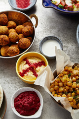 Overhead image of traditional jewish and middle eastern food: falafel, fattoush,  balila, hummus and spicy beetroot dip. Israeli cuisine concept