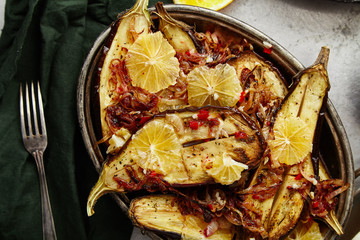 Overhead image of traditional jewish and middle eastern food roasted eggplants with lemon, chili and caramelized onion. Israeli cuisine concept