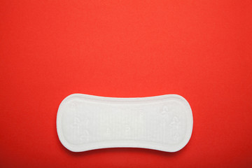 White sanitary napkin on red background, copy space for text.
