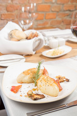 Traditional polish dish called kartacz - potato dumplings stuffed with meat and served with crispy bacon, caramelized onion and fried boletus