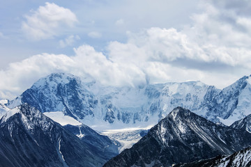Clouds over a mountain covered with snow Belukha from a pass