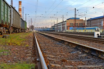 Fototapeta na wymiar Railway station against beautiful sky at sunset. Industrial landscape with railroad, colorful cloudy blue sky. Railway sleepers. Railway junction. Heavy industry. Cargo shipping. Travel background