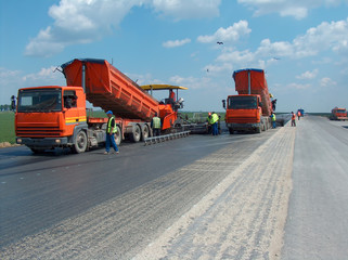 Trucks unload bitumen