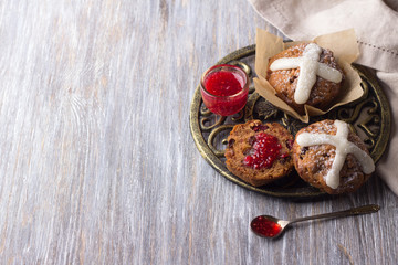 Easter cross muffins with raisins, cranberries and raspberry jam on a wooden table, top view, free space