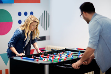 Friends having fun together playing table football