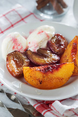 Baked plums and peaches with ice cream and honey and cinnamon