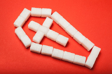 A coffin made of white sugar on a red background, sugar addiction.