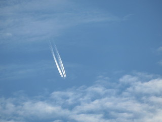 Fototapeta na wymiar Trace of the Jet airplane in the cloudy blue sky. Falling plane concept