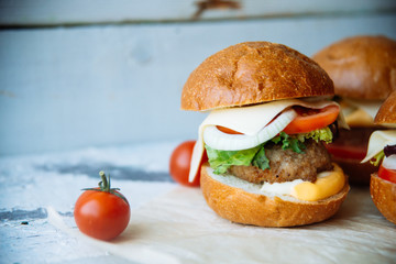 The traditional hamburger Patty, cheese, tomato, lettuce, beef Burger, takeaway. Dark wooden background, horizontal shot.