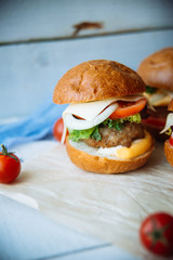 The traditional hamburger Patty, cheese, tomato, lettuce, beef Burger, takeaway. Dark wooden background, horizontal shot.