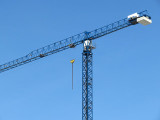 Building crane on the background of clear blue sky