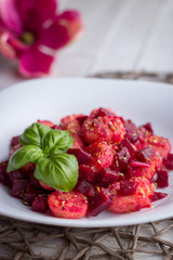 Home-made gnocchi and beet root on white plate