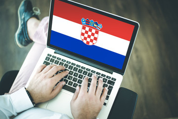 People using laptop and showing on the screen the flag of CROTIA