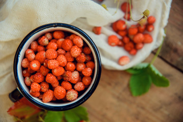 Wild strawberry basket on wooden background
