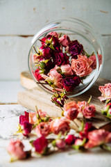 dried rose buds on turquoise wooden surface