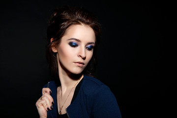 Obraz premium Studio fashion portrait of a girl with professional make-up on a black background close-up