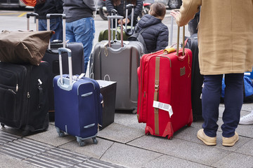 People waiting for a taxi bus with his luggage.