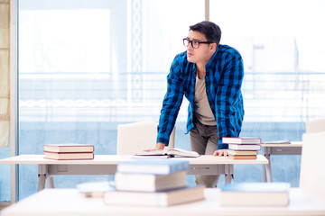 Student studying in the empty library with book preparing for ex