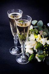 Two glasses of champagne and bouquet of white flowers
