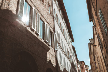 Fototapeta na wymiar Sun reflecting in window of old building in Siena