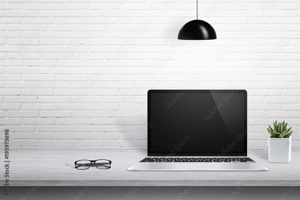 Poster Modern laptop computer on desk with blank screen for mockup. White brick wall in background with free space for text.