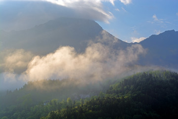Sunlit cloud in mountains