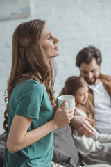 side view of mother holding cup of coffee