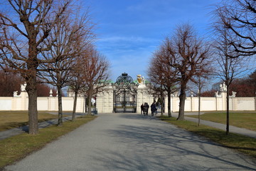 Aleja wiodąca do pięknej bramy wejściowej pałacu Belvedere, Wiedeń, Austria, piękna wczesnowiosenna pogoda, błękitne niebo, grupa turystów przed wejściem - obrazy, fototapety, plakaty