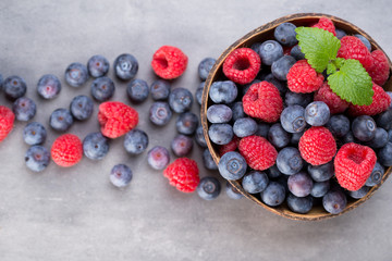 Juicy and fresh blueberries with green mint on rustic gray table.