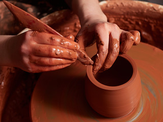 production process of pottery. Forming a clay teapot on a potter's wheel.