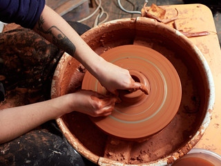production process of pottery. Forming a clay mug on a potter's wheel.