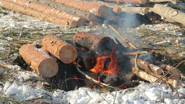 loggers in the winter, warming themselves by the fire