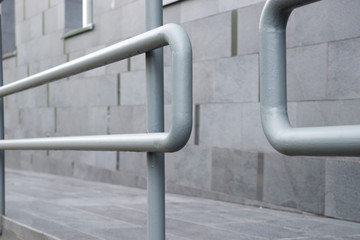 Metal pipe railings of the ramp near the building.