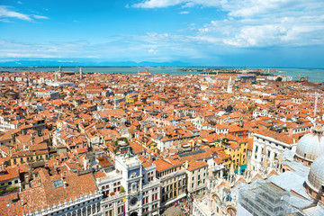 Fototapeta premium Aerial view on Venice roofs, houses, sea and people on square from San Marco tower