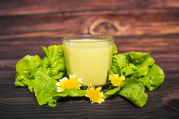 Healthy mango smoothie in a glass, on a rustic white wood background